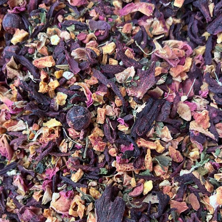 A close-up of dried herbal tea leaves and pieces, showing a mix of red, brown, and beige tones.